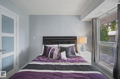 Bedroom featuring light blue walls and a full-light panel door - #39 3111 142 Av Nw, Edmonton, AB - Indoor Photo Showing Bedroom
