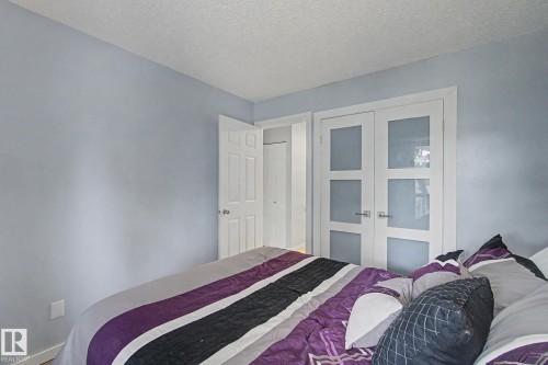Crisp white trim frames a light blue wall, complemented by an opaque glass panel door and a traditional paneled door - #39 3111 142 Av Nw, Edmonton, AB - Indoor Photo Showing Bedroom