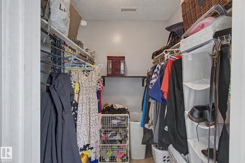 Walk-in closet featuring built-in shelving, hanging rods, light gray wall paint, and recessed ceiling lighting - #39 3111 142 Av Nw, Edmonton, AB - Indoor With Storage