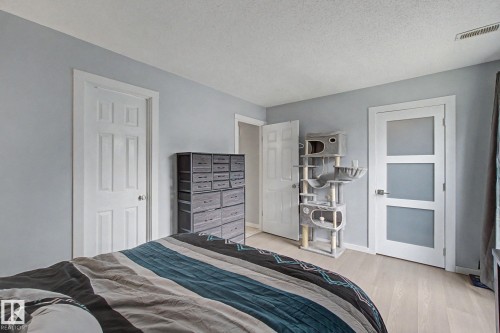 Light-toned wood-finish flooring complements the neutral wall color - #39 3111 142 Av Nw, Edmonton, AB - Indoor Photo Showing Bedroom