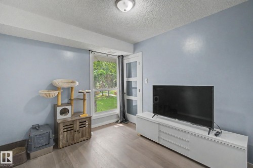 Room featuring light blue walls and wood-finish flooring - #39 3111 142 Av Nw, Edmonton, AB - Indoor Photo Showing Other Room