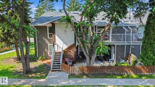 Multi-level residence featuring gray horizontal siding and light-colored stucco elements - #39 3111 142 Av Nw, Edmonton, AB - Outdoor
