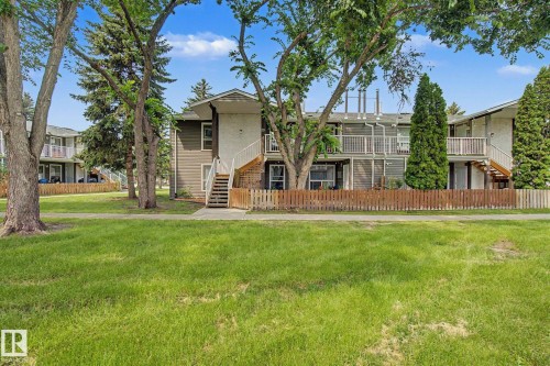 Multi-level residential building featuring exterior staircases, individual balconies, and a wooden fence - #39 3111 142 Av Nw, Edmonton, AB - Outdoor