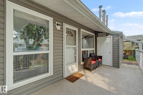 Covered concrete patio with grey horizontal siding and white trim - #39 3111 142 Av Nw, Edmonton, AB - Outdoor With Exterior