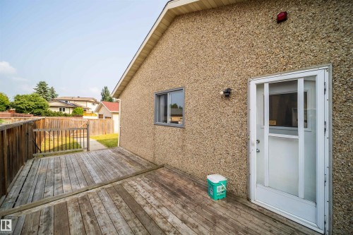 Exterior with a wood-finish deck, stucco siding, and a white entry door - 1719 37 Street Nw, Edmonton, AB - Outdoor With Deck Patio Veranda With Exterior