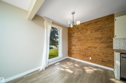Accent wall with horizontal wood paneling, wood-finish flooring, and a multi-bulb ceiling fixture - 