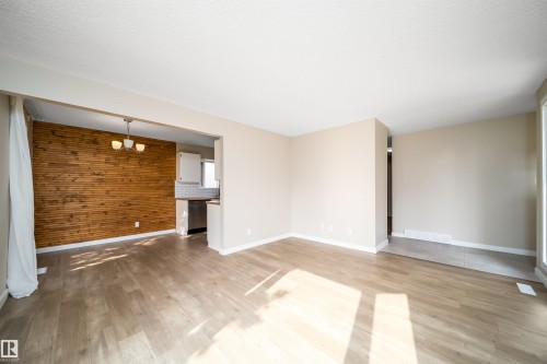Open living area with wood-finish flooring and neutral wall tones - 1719 37 Street Nw, Edmonton, AB - Indoor