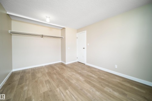 Room featuring wood-finish flooring, neutral wall tones, and white trim - 1719 37 Street Nw, Edmonton, AB - Indoor Photo Showing Other Room