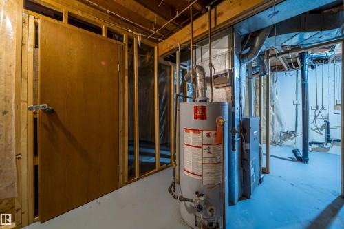 Utility area featuring exposed wood framing, a water heater, and a furnace unit - 1719 37 Street Nw, Edmonton, AB - Indoor Photo Showing Basement