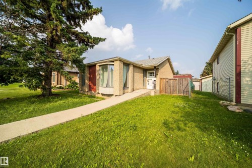Single-story exterior with light-colored siding, a prominent bay window, and a concrete pathway leading to the entry - 1719 37 Street Nw, Edmonton, AB - Outdoor
