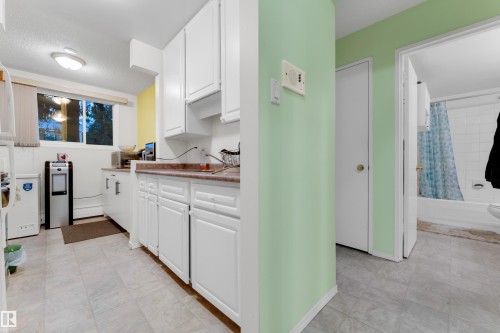 Kitchen featuring white cabinetry, a window, and wood-finish countertops - #104 11445 41 Av Nw, Edmonton, AB - Indoor