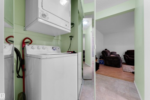 Dedicated laundry area featuring a stacked washer and dryer unit - #104 11445 41 Av Nw, Edmonton, AB - Indoor Photo Showing Laundry Room