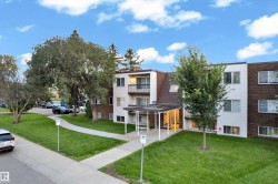 Multi-story building featuring a pitched shingle roof and a combination of white siding and dark brick exterior - 