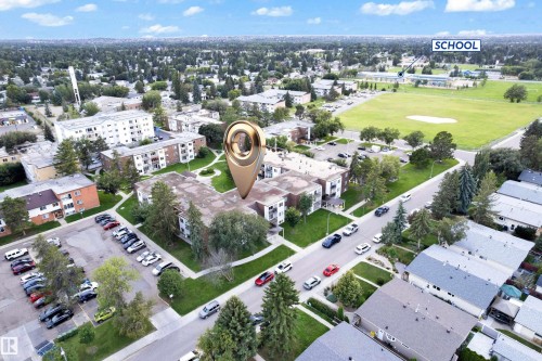 Aerial perspective showcasing a multi-unit residential building with surrounding green spaces - #104 11445 41 Av Nw, Edmonton, AB - Outdoor With View