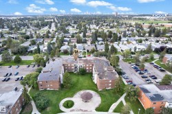 Aerial perspective showcasing a multi-building complex with brick exteriors and surrounding green spaces - 