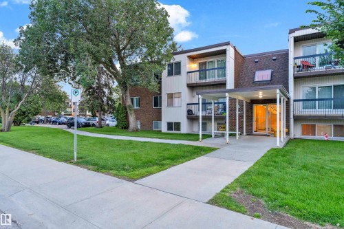 Multi-story residential building featuring a covered entryway, private balconies with dark railings, and a dark shingle roof - #104 11445 41 Av Nw, Edmonton, AB - Outdoor With Facade