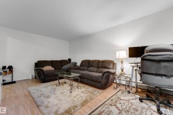 Spacious room featuring light wood-finish flooring, white walls, and a textured ceiling - 