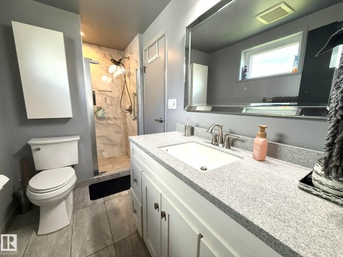 Bathroom featuring a white vanity with a light-toned countertop and an undermount sink - 4508 57 Avenue, Lamont, AB - Indoor Photo Showing Bathroom