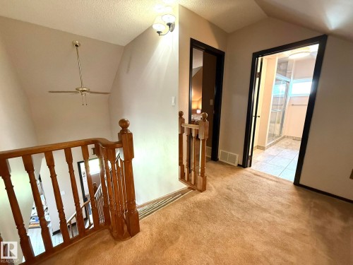 Upper level landing featuring wood balustrade, sloped ceiling, and recessed lighting - 4508 57 Avenue, Lamont, AB - Indoor Photo Showing Other Room