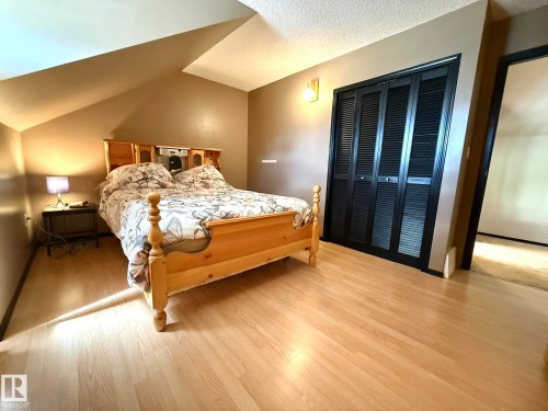 Slanted ceiling architecture featuring light wood-finish flooring - 4508 57 Avenue, Lamont, AB - Indoor Photo Showing Bedroom