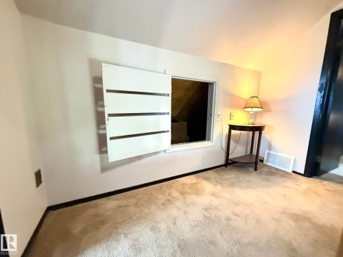 Carpeted space featuring an open access panel with louvered doors - 4508 57 Avenue, Lamont, AB - Indoor Photo Showing Other Room