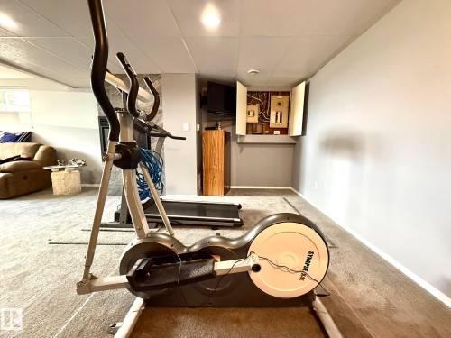 Lower level recreation space featuring neutral wall paint, carpet flooring, a drop ceiling, and recessed lighting - 4508 57 Avenue, Lamont, AB - Indoor Photo Showing Gym Room