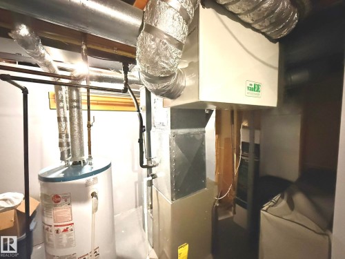 Central utility area featuring a water heater, furnace, and ventilation system - 4508 57 Avenue, Lamont, AB - Indoor Photo Showing Basement