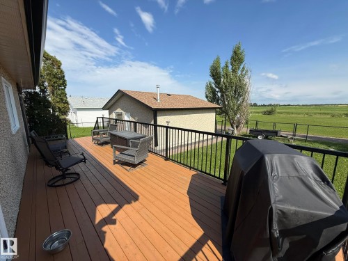 Spacious outdoor deck with wood-finish flooring and black railing - 4508 57 Avenue, Lamont, AB - Outdoor With Deck Patio Veranda With Exterior