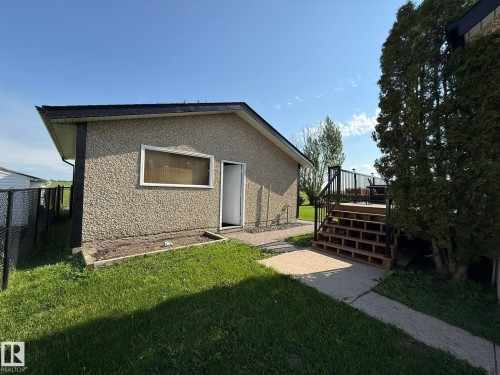 Exterior building with textured stucco finish, a black shingle roof, and a single window - 4508 57 Avenue, Lamont, AB - Outdoor