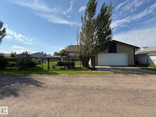 Detached garage with a white overhead door and an asphalt driveway - 4508 57 Avenue, Lamont, AB - Outdoor
