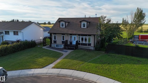 Charming brick colonial with a mansard roof and dormer windows, set on a manicured lawn with mature landscaping - 4508 57 Avenue, Lamont, AB - Outdoor With Deck Patio Veranda