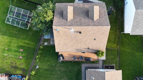 Shingled roofing with twin prominent chimney structures - 4508 57 Avenue, Lamont, AB - Outdoor