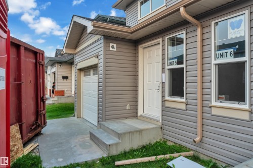 Entryway featuring a panel door, two vertical windows with trim, and concrete steps - #5 18004 89 St Nw, Edmonton, AB - Outdoor With Exterior