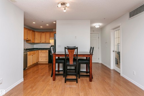 Open-concept living area with wood-finish flooring - #106 12110 106 Av Nw, Edmonton, AB - Indoor
