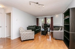 Open-concept living area featuring wood-finish flooring, a built-in fireplace with a tile surround, and a built-in dark wood shelving unit - 
