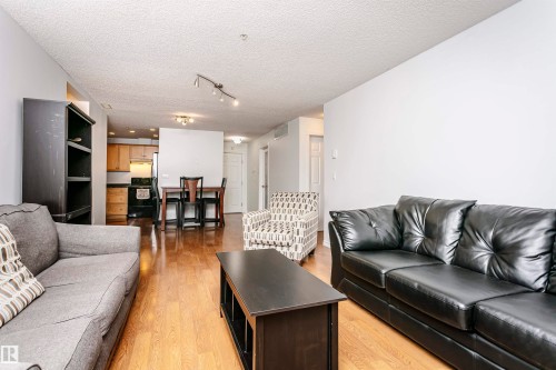 Open-concept living area featuring wood-finish flooring, recessed lighting, and track lighting - #106 12110 106 Av Nw, Edmonton, AB - Indoor Photo Showing Living Room