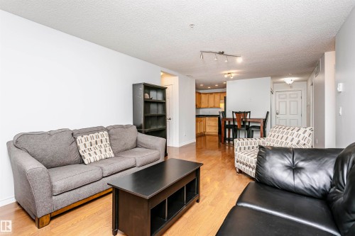 Open concept living area featuring wood-finish flooring - #106 12110 106 Av Nw, Edmonton, AB - Indoor Photo Showing Living Room