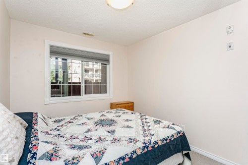 Neutral wall paint with baseboard trim - #106 12110 106 Av Nw, Edmonton, AB - Indoor Photo Showing Bedroom