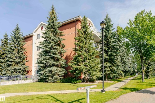 Multi-story building featuring a brown and cream facade, multiple windows, and a curved balcony railing - #106 12110 106 Av Nw, Edmonton, AB - Outdoor