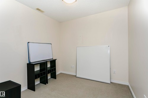 Room with neutral wall paint and light-colored carpeting, featuring white baseboards and a ceiling light fixture - #106 12110 106 Av Nw, Edmonton, AB - Indoor Photo Showing Other Room