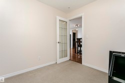 Interior room featuring light-toned walls, neutral carpet flooring, and white baseboards - 