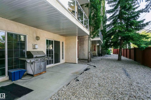 Concrete patio with two sliding glass doors and an overhead covering - #106 12110 106 Av Nw, Edmonton, AB - Outdoor With Exterior