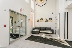 Spacious entry hall featuring double glass doors, high ceilings, large windows, and light-toned tile flooring - 