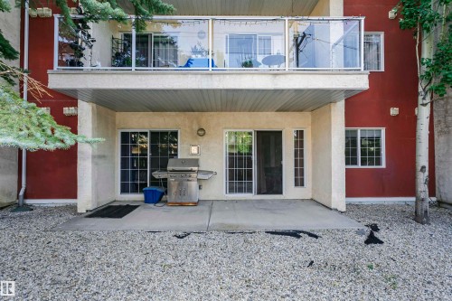 Ground-level patio featuring concrete surfacing and direct access via sliding glass doors - #106 12110 106 Av Nw, Edmonton, AB - Outdoor With Exterior