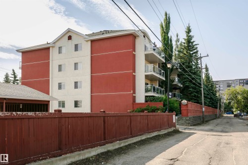 Multi-story building featuring red and cream-colored exterior walls with multiple window units - #106 12110 106 Av Nw, Edmonton, AB - Outdoor