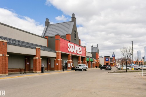 Retail plaza featuring brick columns, prominent signage, a large storefront, and ample parking - #106 12110 106 Av Nw, Edmonton, AB - Outdoor