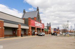 Retail plaza featuring brick columns, prominent signage, a large storefront, and ample parking - 