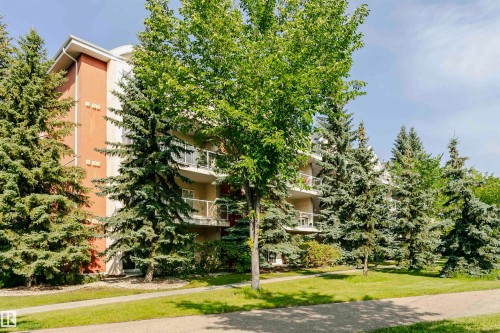 Multi-story building featuring a stucco exterior with orange and cream-colored panels - #106 12110 106 Av Nw, Edmonton, AB - Outdoor