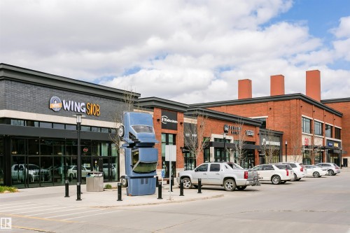 Commercial building showcasing a brick and dark facade with large storefront windows - #106 12110 106 Av Nw, Edmonton, AB - Outdoor