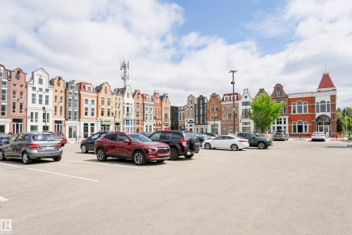 Spacious paved parking area with marked spaces - #106 12110 106 Av Nw, Edmonton, AB - Outdoor With Facade